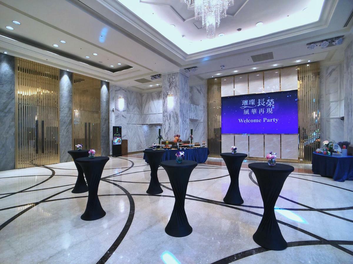 Evergreen Laurel Hotel - Тайчжун Экстерьер фото The photo depicts a spacious and elegantly decorated event space, likely set up for a welcome party. The room features polished marble flooring and tall ceilings, giving it a sophisticated atmosphere. In the center, several round tables with black ta