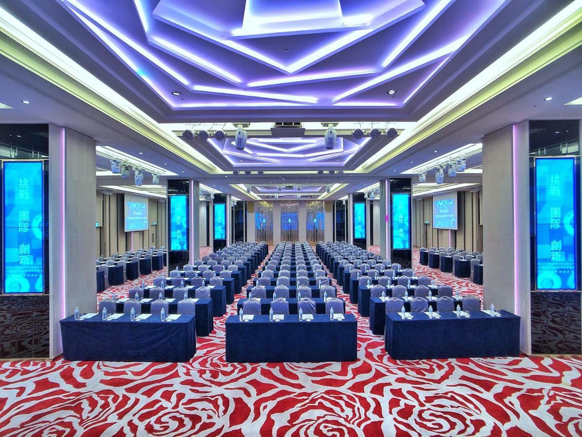 Evergreen Laurel Hotel - Тайчжун Экстерьер фото The photo shows a large conference or seminar room set up for an event. The space features rows of tables and chairs arranged neatly, likely for attendees to participate in discussions or presentations. The room is well-lit with modern, colorful ligh